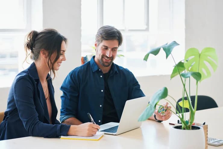 Two colleagues reviewing finances on a laptop